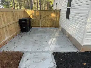 Freshly poured concrete driveway extension at a new construction home, ready for finishing touches.