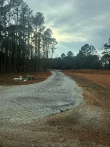 Phase 2 berm and driveway construction: D3 dozer pushing fill to create a 12–14 foot privacy berm along Olde Creedmoor Road and forming the base for a new winding rock driveway with ABC and #57