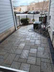 Newly installed Techo-Bloc Slate Champagne Grey paver walkway with Onyx Black border in Cary, NC by MWM Landscaping & Grading. Proper grading directs water away from the house foundation after a rainstorm.