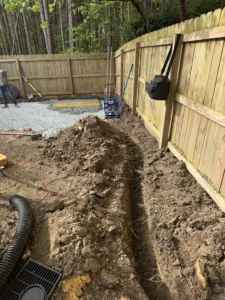 Drainage system installation in Durham NC with catch basins and underground piping to redirect water away from yard