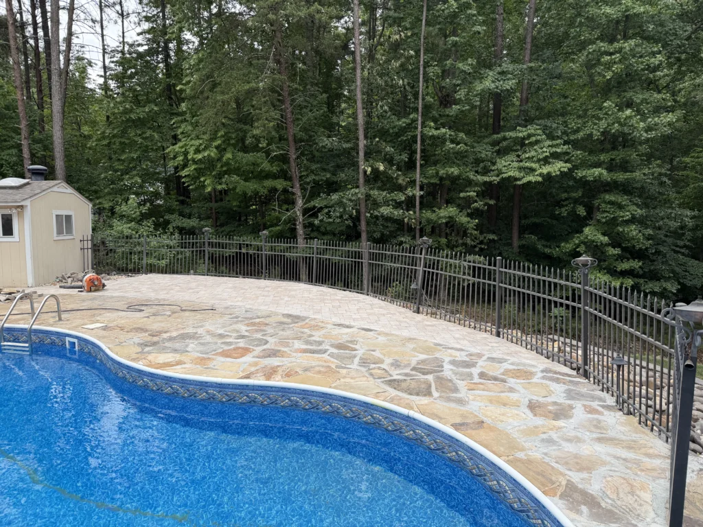 Restored natural flagstone pool patio with newly installed Belgard pavers creating an expanded outdoor living space at a North Raleigh home.