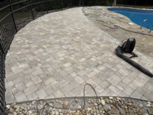 Completed hardscaping project featuring Belgard pavers and restored natural flagstone surrounding a residential pool in North Raleigh, NC.