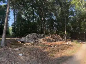Pile of debris from a demolished house in Asheboro, NC following a property preparation project by MWM Landscaping & Grading, clearing the site for future construction.