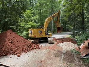 MWM Landscaping & Grading crew member compacting soil during excavation for a culvert replacement project in Pittsboro